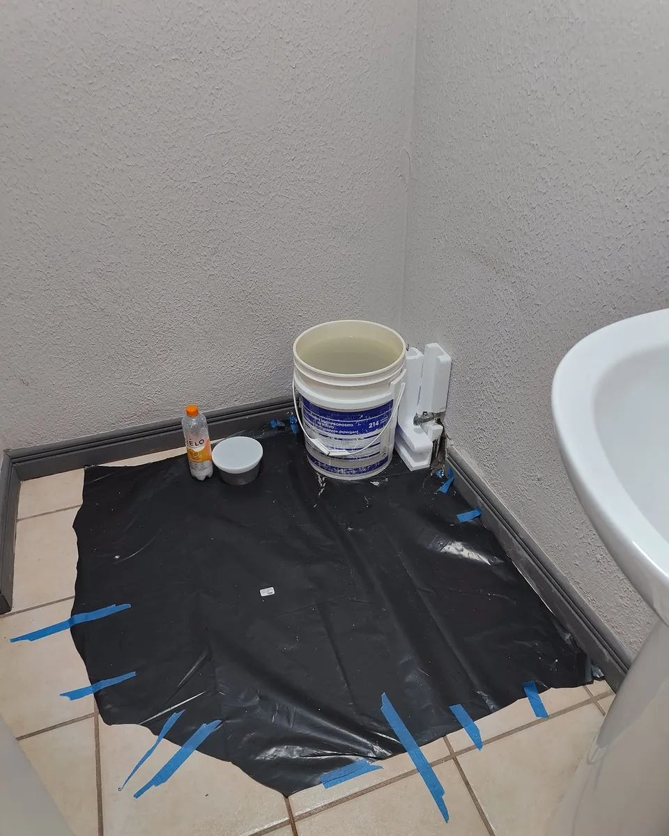 Piso protegido antes de restaurar el acabado de la pared
